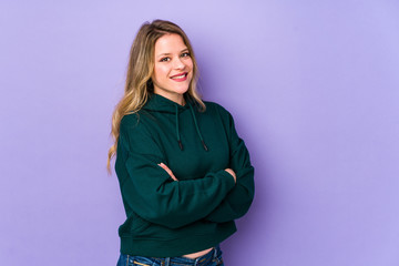 Young caucasian woman isolated on purple background happy, smiling and cheerful.