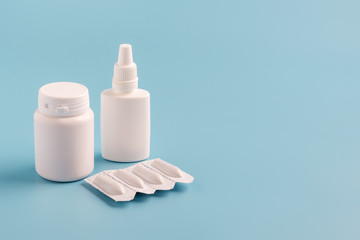 two white plastic bottles for pills without labels and suppositories packaging