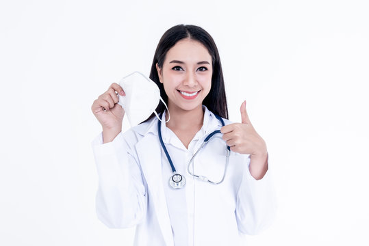 Portrait images of Asian woman doctor holding a mask and use her hand to make a great symbol, concept to health care and primary disease prevention, such as PM 2.5 and coronavirus