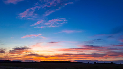 Fototapeta na wymiar Dramatic sunset sky with clouds over field