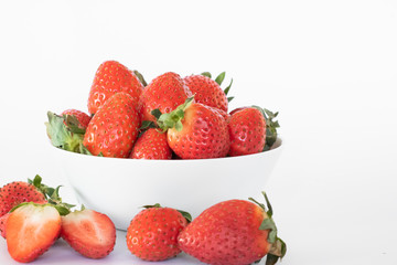 White plate with large ripe fresh strawberries on a white background