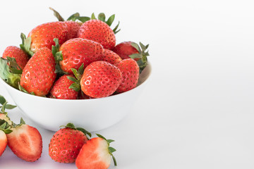 White plate with large ripe fresh strawberries on a white background