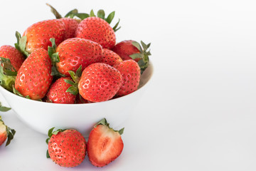White plate with large ripe fresh strawberries on a white background