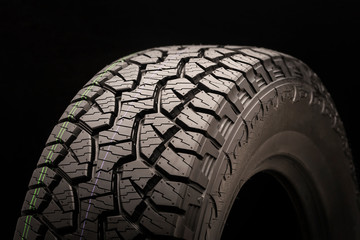 mud all terrain tires for SUVs on a black background close-up, slats and ground hooks, drainage...