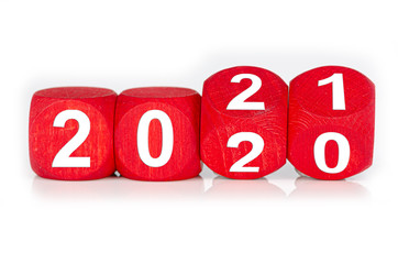 wooden cube with year 2020 and 2021 built from red dices, isolated on white background