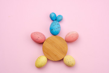 Closeup of a rabbit made of eggs and a wooden circle on the table. Easter concept