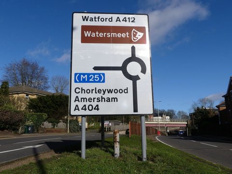 Road sign on A412 in Rickmansworth, Hertfordshire, UK with directions to Chorleywood, Amersham and the M25 motorway plus Watford and the Watersmeet arts and entertainment venue