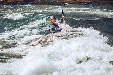 Guy in kayak sails mountain river. Whitewater kayaking, extreme sport rafting