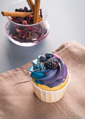 Delicious cake on a linen tablecloth. Cupcake with whipped cream. Beautiful sweets.