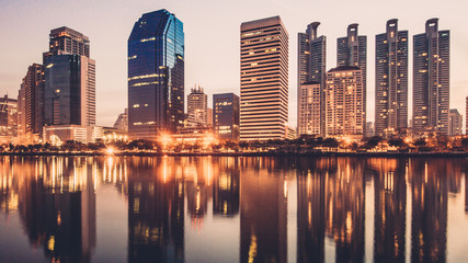 Fototapeta na wymiar Business district cityscape from park,Benchakitti Park in Morning with cityscape reflection, Bangkok Thailand.