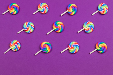Lollipops are arranged symmetrically on a colored background. colorful candies