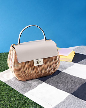 Straw basket purse on picnic blanket