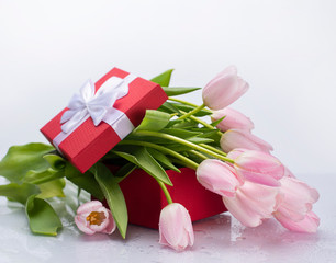 bouquet of pink tulips and a red box with a gift on a white isolated background