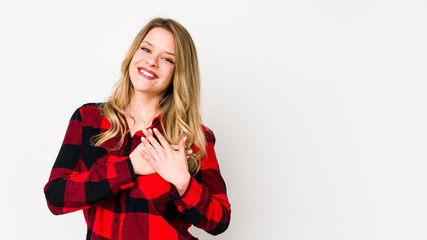 Fototapeta premium Young cauciasian woman isolated on white background has friendly expression, pressing palm to chest. Love concept.