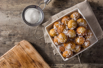 Carnival fritters or buñuelos de viento in bowl for holy week on wooden table