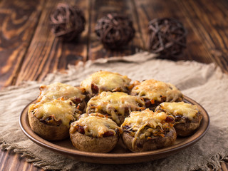 baked mushrooms with vegetables and cheese on a plate.