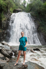 Woman at Korbu Waterfall on the Lake Teletskoye in autumn Altai Mountains.