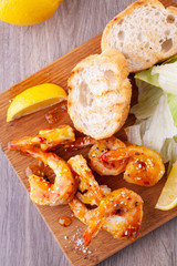 grilled tiger shrimps with spices, sweet and sour sauce, lemon and lettuce