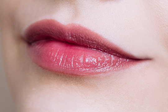 Beautiful closeup female plump lips with nude color makeup.