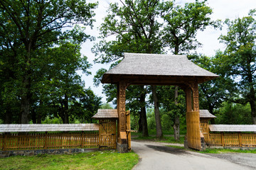 The traditional Maramures wooden gate, the wooden church of the Peri-Sapanta Monastery.