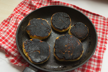 burnt pancakes, cheesecakes, food in a pan. Fried foods are unhealthy.