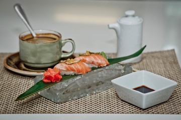 Beautiful serving of sushi on ice and hot coffee