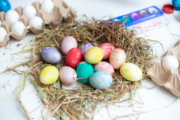 Baby paints Easter eggs with brush and watercolor