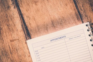 Organizer or planner. Vintage style appoinments list on a wooden table.