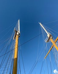 Obraz premium Wooden ship masts in the blue sky background