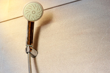 Shower tap on bath room wall with sun light with reflection