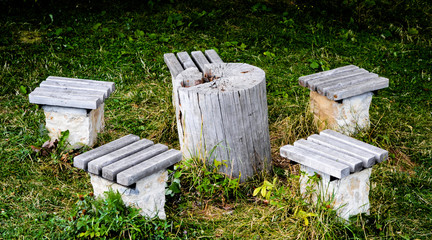 Table made from a stump with chairs on a green grass