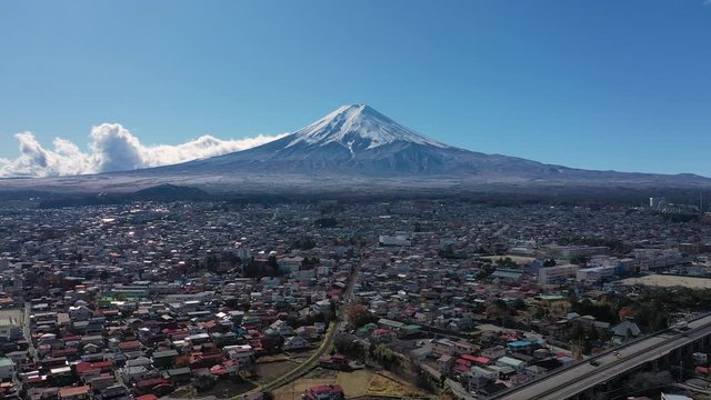 Aerial view of city Fujiyoshida in late Autumn, snow-capped Mount Fuji in background - landscape panorama of Japan from above, Asia