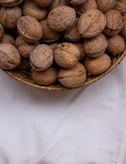 Walnut. Small wicker basket filled with walnuts on a white background