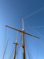 Wooden ship masts in the blue sky background