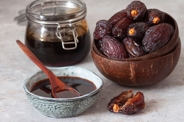 Natural date syrup in a bowl with whole dates in the background