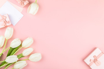 Fototapeta na wymiar White tulip on pastel pink background. Traditional holiday gift.