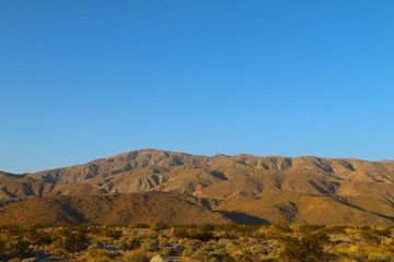 blue sky rolling desert mountains horizon