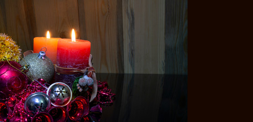 Christmas concept banner with two red candles lighting on wooden background