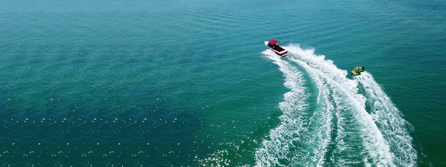 Aerial drone ultra wide photo of fit man practising water ski powered by watercraft in exotic open...