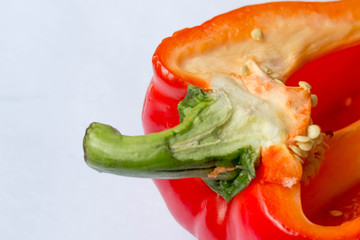 red bell pepper in a longitudinal section on a white background close-up with a peduncle