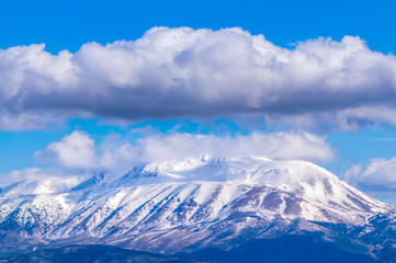 Fototapeta na wymiar Snowy mountain with clouds, sunny winter day. Davraz Mountain at Isparta / Turkey.