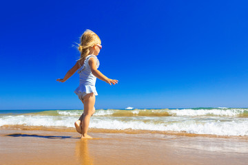 Fototapeta na wymiar Happy child jumping in sandy beach