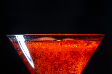 bright cocktail with red orange on a black background