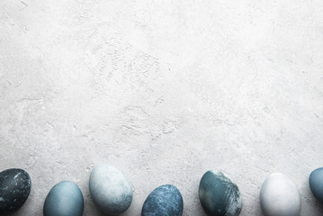 Naturally dyed colorful Easter eggs on grey concrete background