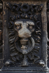 Architectural detail in the form of lion’s muzzle. Ancient architecture. Ruins of temples and castles sooty from age. Damaged by time