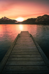 sunrise at the lake on a pier with panorama view to the mountains