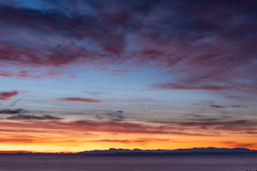 Fototapeta premium sunrise at the lake on a pier with panorama view to the mountains