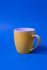 Yellow color big mug over blue background.