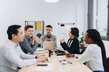 Group of multicultural businesspeople listening their boss speech - asian man manager talking to his team