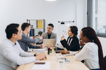 Group of multicultural businesspeople listening their boss speech - asian man manager talking to his team